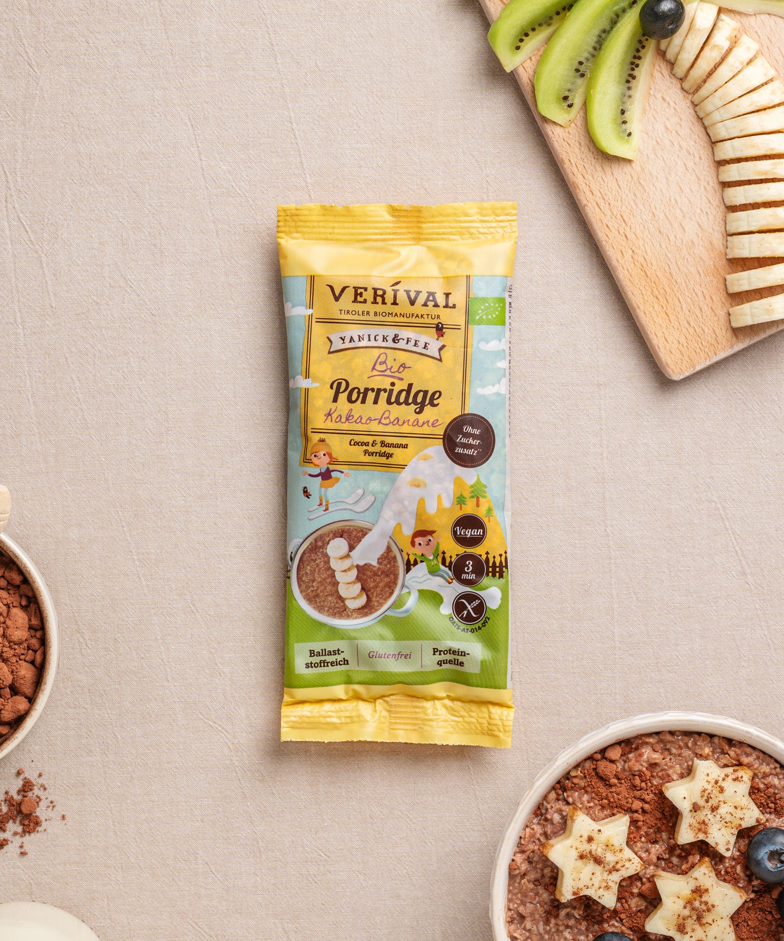 Eine Einzelportionspackung Verival Bio Kids Porridge Kakao-Banane, ein glutenfreier Porridge, garniert mit sternförmigen Bananen, Kiwischeiben, Kakaopulver und saftigen Heidelbeeren – ein geschmackvolles Festmahl, reich an wichtigen Ballaststoffen.